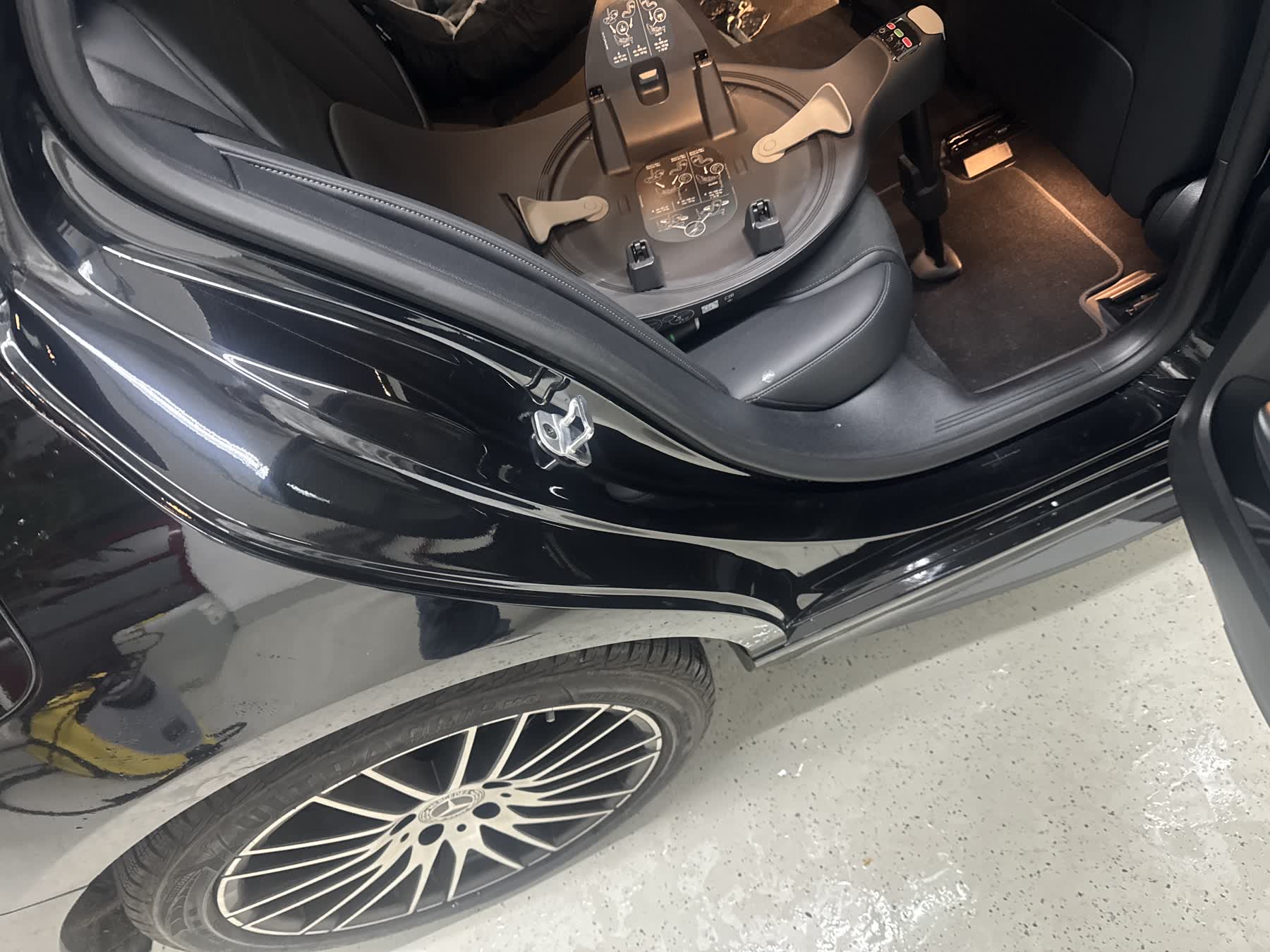 Folierter Einstiegsbereich an einem schwarzen Mercedes mit Kindersitz-Basis auf der Rückbank