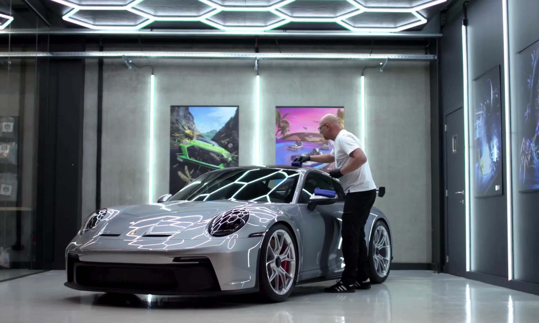 Detailer arbeitet an einem Porsche 911 GT3 unter Hexagon-Lichtlinien